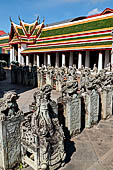 Bangkok Wat Arun - Detail of the precint of the sacred area of the ubosot with chinese dragons and noble man sitting on chair. 